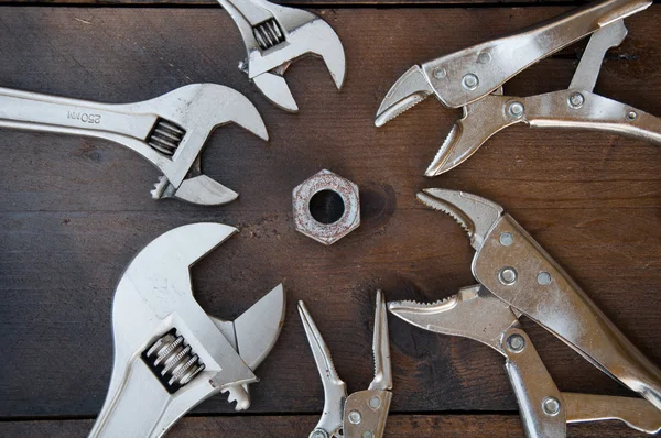 Verstellbarer Schrauben- oder Schlüsselschlüssel und Verriegelungszange auf Holzgrund, bereiten grundlegende Handwerkzeuge für die Arbeit vor. — Stockfoto