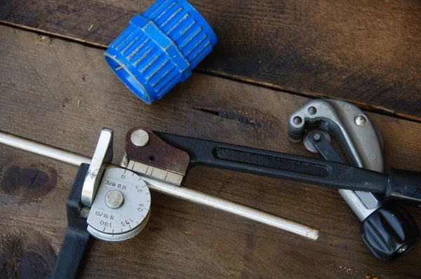 Doblador de tubo o doblador de tubería herramientas sobre fondo de madera . — Foto de Stock