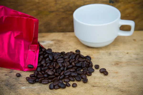 Fondo de granos de café en madera, Granos de café frescos con taza de café sobre fondo de madera, Fondo de juego de beber . — Foto de Stock