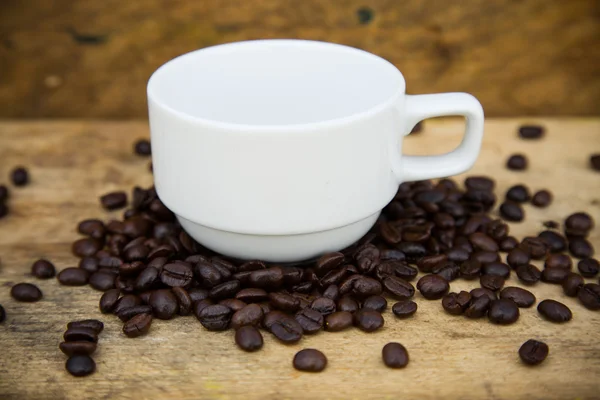 Fondo de granos de café en madera, Granos de café frescos con taza de café sobre fondo de madera, Fondo de juego de beber . — Foto de Stock