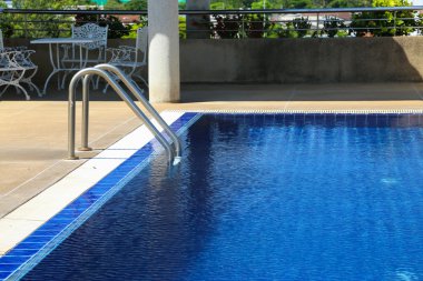 Swimming pool with sunny reflections on good weather day. Relax time with family on swimming pool. Popular sport.