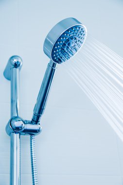 Mavi ve serin resim stili, banyo ekipmanları akan suyla banyoda gümüş duş başlığı damla.