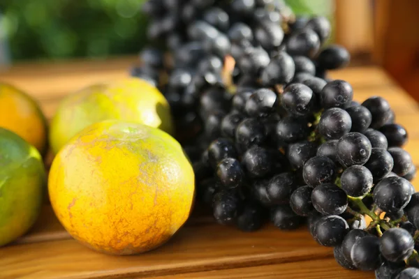 Ягоды или виноград и апельсин на фоне, концепция здоровых фруктов, популярные фрукты или рыночные фрукты . — стоковое фото