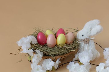 Renkli yumurta ve beyaz tavşanlı Paskalya süslemesi.