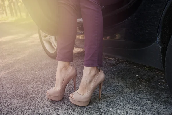 Frauenbeine in High Heels im Auto im Freien — Stockfoto