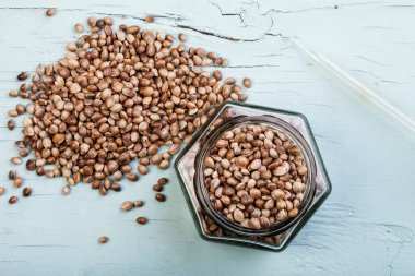 Mavi ahşap arka planda izole kenevir tohumları