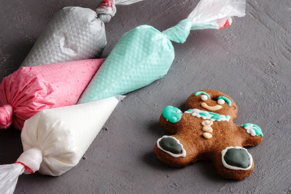 カラフルな装飾のための使い捨て調理注射器に異なる色の砂糖ペースト クリスマスと新年の伝統的な自家製ジンジャーブレッドクッキーデザート — ストック写真