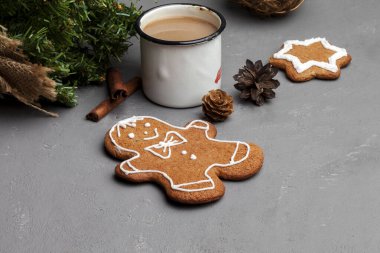 Dekoratif Noel natürmort. Gri desenli masa arkasında kurabiye şeklinde zencefilli adam kışı kompozisyonu. Bir fincan kahve, kahvaltı. Düz yerde, üst tarafta. Boşluğu kopyala