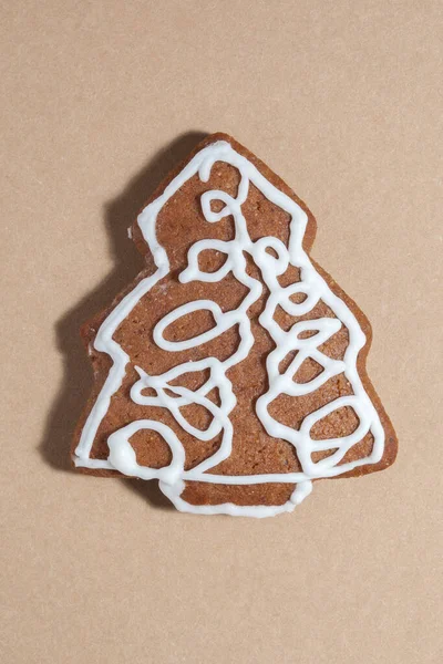 クラフト紙に隔離されたモミの木の形をしたジンジャーブレッド ミニマリズム クリスマスの構図 — ストック写真