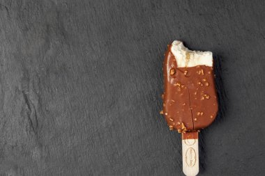 KIEV, UKRAINE - 24 Aralık 2020: Tuzlu karamelli vanilyalı Hagen-Dazs dondurması ve ahşap bir çubukta çikolata jöleli fındık. Siyah grafit arkaplanda izole