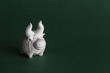 Yeşil arka planda beyaz bir boğanın seramik figürü. Boğa 2021 'in sembolüdür..