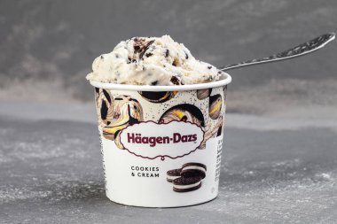 KIEV, UKRAINE - January 03, 2021: Mini cup of cookies. HAAGEN-DAZS vanilla ice cream with chocolate chip cookies on a gray background
