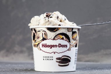KIEV, UKRAINE - January 03, 2021: Mini cup of cookies. HAAGEN-DAZS vanilla ice cream with chocolate chip cookies on a gray background