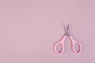 Pembe arka planda pembe tırnak makasları düz fotokopi alanı. Metal ve plastik tırnak makası. Manikür makası.