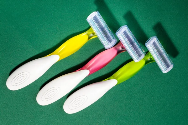 Three Women Colorful Razors Selective Focus Green Background New Disposable — Stock Photo, Image