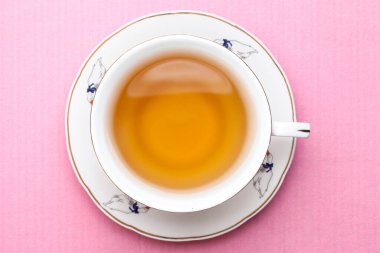 Pastel pembe renkte bir fincan çay. Yukarıdan görüntüle