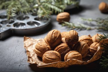 Noel ağacının arka planında yoğunlaştırılmış süt olan fındık şeklinde kurabiyeler. Noel hediyesi