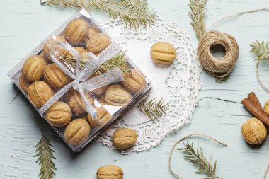 El yapımı bir hediye. Ahşap zemin üzerinde yoğunlaştırılmış sütle birlikte fındıklı kurabiyeler. Noel yenilebilir hediye konsepti.