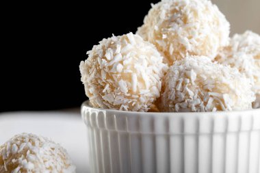 Hindistan cevizi topları, çiğ ve sağlıklı rafaello şekerleri. Vejetaryen enerji tatlısı adım adım tarifi verir. Seramik kasede yuvarlak lezzetli tatlı. Uzayı kopyala, görüntüyü kapat. Çocuklar için sağlıklı organik yiyecekler.