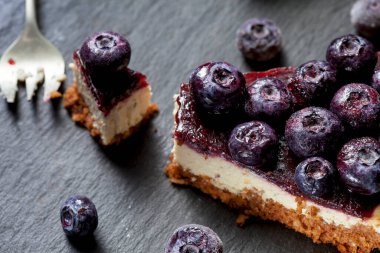 Çilekli tofu peynirli kek dilimi. Vejetaryen tatlı, şeker, glüten ve laktozsuz. Siyah bir arkaplanda