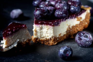 Çilekli tofu peynirli kek dilimi. Vejetaryen tatlı, şeker, glüten ve laktozsuz. Siyah bir arkaplanda
