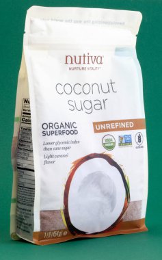 KIEV, UKRAINE - 18 Şubat 2021: Nutiva Organik Hindistan cevizi şekeri hindistan cevizi ağaçlarının taze bitki özsuyundan yapılır. Yeşil arkaplanda ambalaj