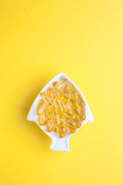 鳕鱼肝油胶囊呈黄底鱼的形状 — 图库照片