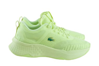 KIEV, UKRAINE - 25 Haziran 2021. Beyaz arka planda LACOSTE spor ayakkabıları. Beyaz arka planda açık yeşil spor ayakkabılar