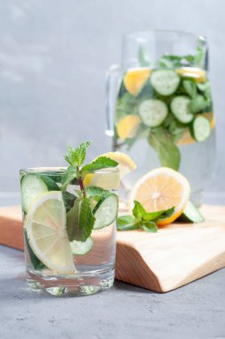 Soğuk yaz limonatası, salatalık ve taş kavanozlarda naneli taş, taş ya da beton arka plan..