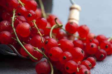 Gri bir masada metal kovada taze üzümlü üzümler. Bir kova böğürtlen döküldü.