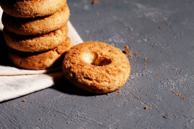 Tahta masadaki beyaz keten peçetede kurabiyeler. Yuvarlak bisküviler