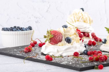 Taze çilek ve yabanmersinli kremalı pasta. Pasta Anna Pavlova. Kapat..