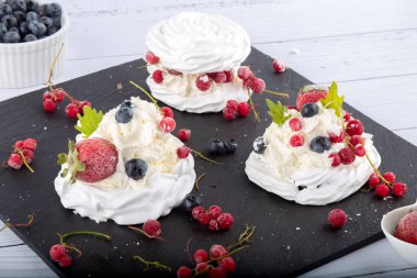 Taze çilek ve yabanmersinli kremalı pasta. Pasta Anna Pavlova. Kapat..