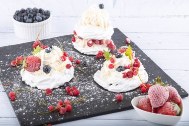 Taze çilek ve yabanmersinli kremalı pasta. Pasta Anna Pavlova. Kapat..