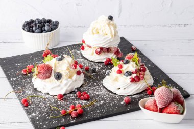 Taze çilek ve yabanmersinli kremalı pasta. Pasta Anna Pavlova. Kapat..