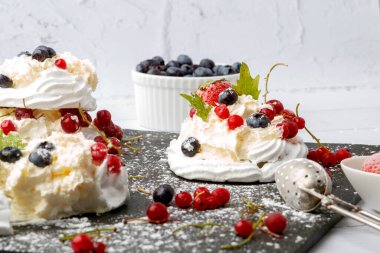 Taze çilek ve yabanmersinli kremalı pasta. Pasta Anna Pavlova. Kapat..