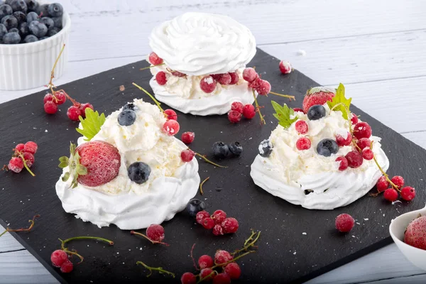 Taze çilek ve yabanmersinli kremalı pasta. Pasta Anna Pavlova. Kapat..