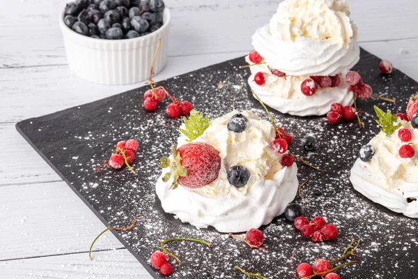 Anna Pavlova pastası üzümlü, yaban mersinli ve çilekli. Siyah mermer bir tabakta