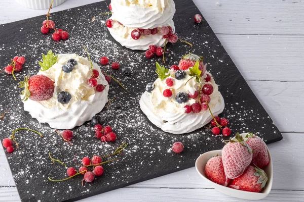 Anna Pavlova pastası üzümlü, yaban mersinli ve çilekli. Siyah mermer bir tabakta