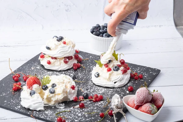 Anna Pavlova pastası üzümlü, yaban mersinli ve çilekli. Siyah mermer bir tabakta