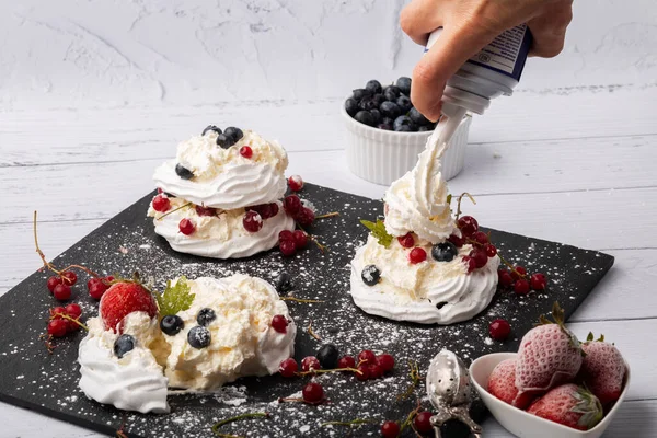 Anna Pavlova pastası üzümlü, yaban mersinli ve çilekli. Siyah mermer bir tabakta