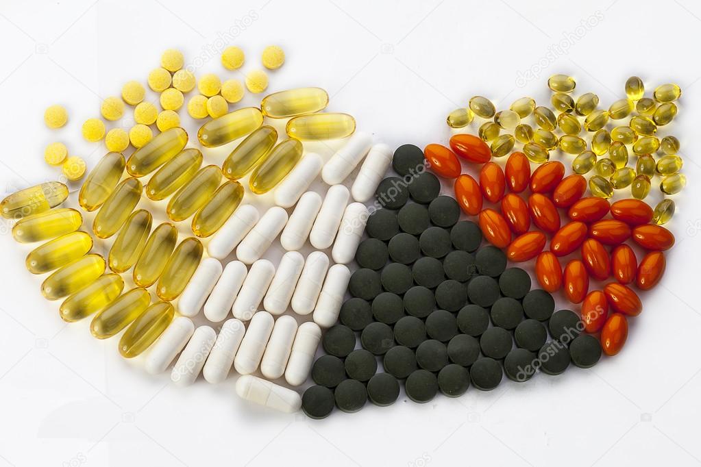 Open cans of white plastic with colorful capsules. Complex drugs