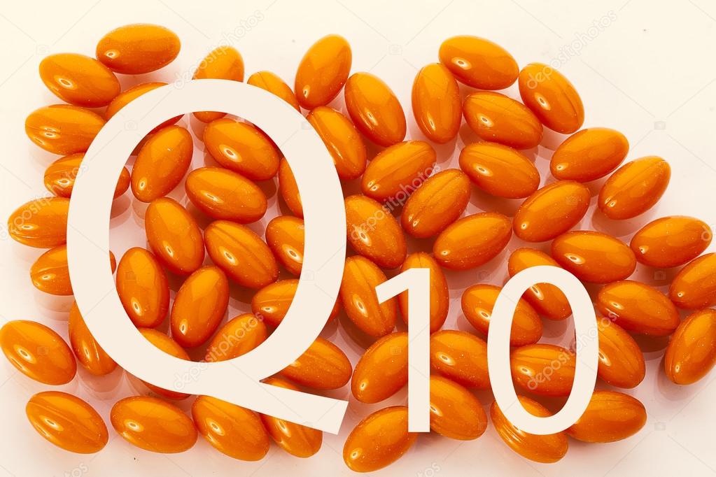 辅酶q10。题字为背景的橙色胶囊——图库图片© OlesyaKuzina #75653637