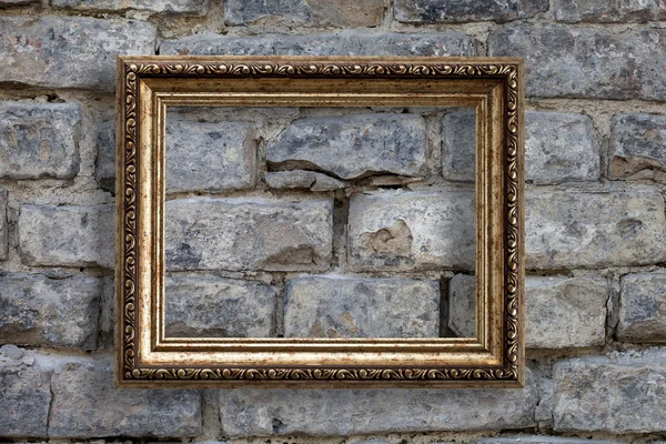 Leeg gouden frame op een bakstenen muur achtergrond — Stockfoto