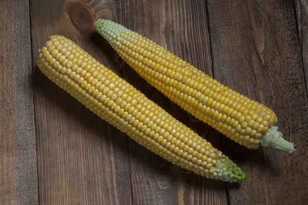 Mais auf dem Kolben, isoliert auf hölzernem Hintergrund — Stockfoto