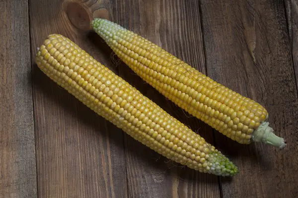 Maïs op de kolf, geïsoleerd op houten achtergrond — Stockfoto