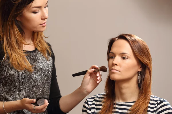 Kosmetolog gör vackra makeup klient — Stockfoto