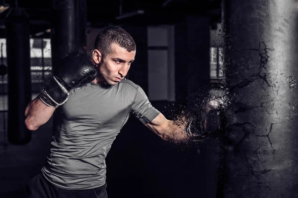 Boxer punch punching bag exploding in gym — Stock Photo, Image