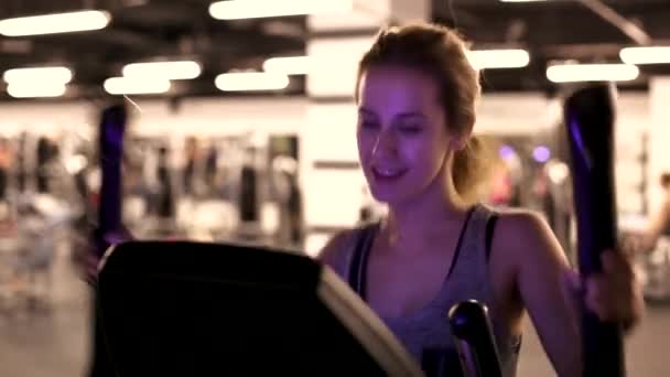Dziewczyna w siłowni na eliptyczny trener — Wideo stockowe
