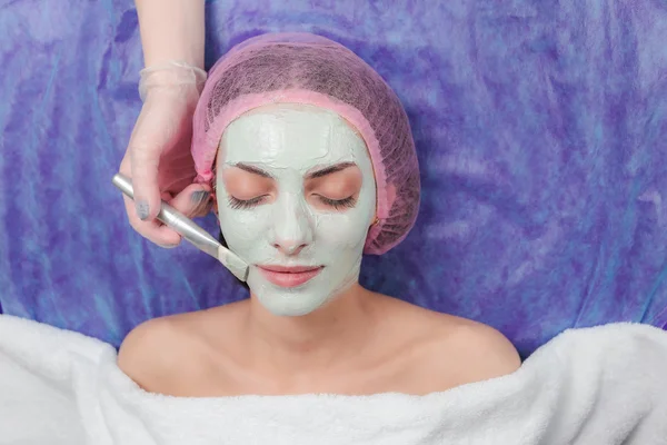 Retrato de menina bonita aplicando tratamentos de beleza máscara de barro facial — Fotografia de Stock